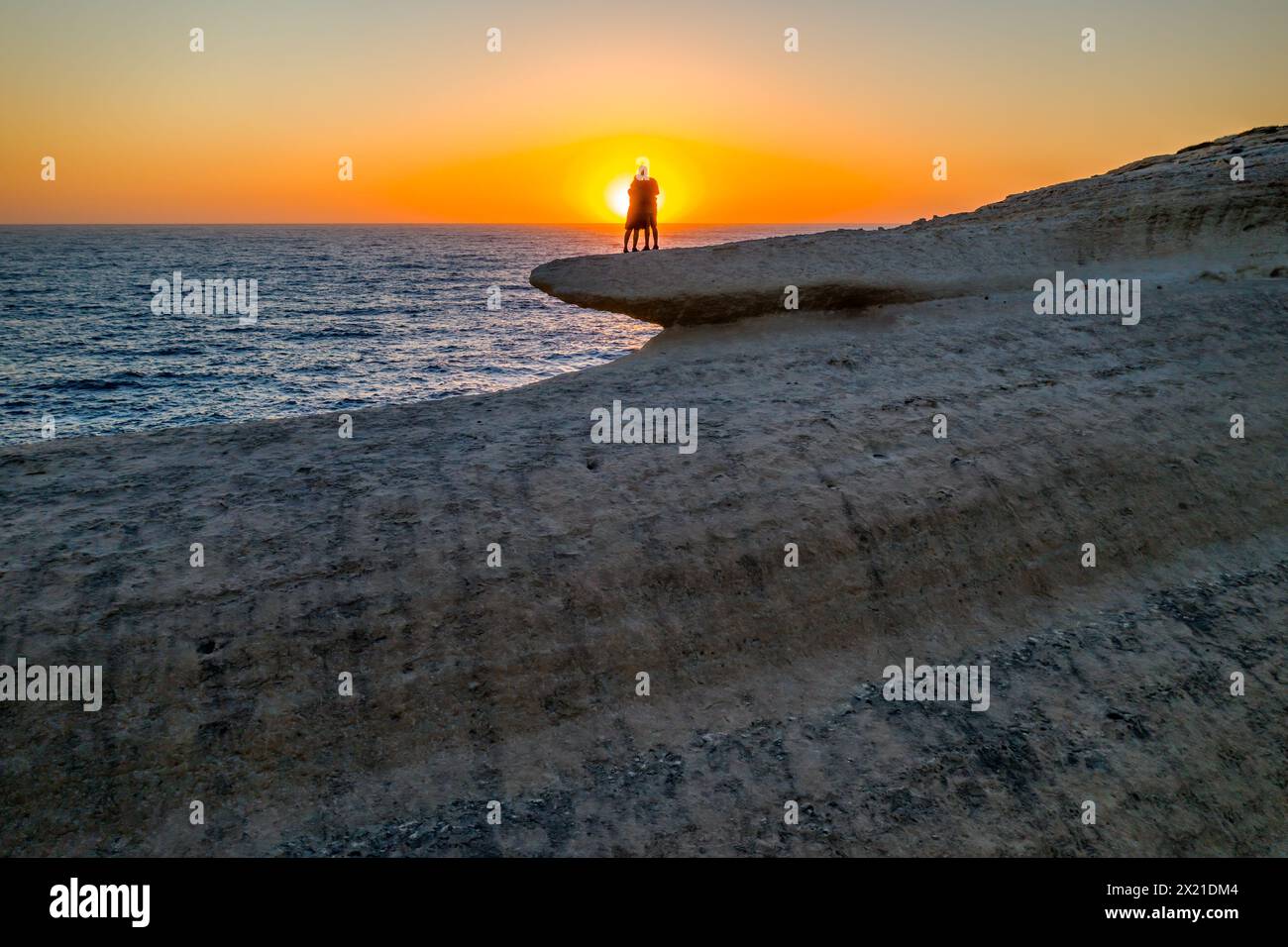 Vue de la silhouette d'un couple serrant eachother au sommet d'une falaise de mer Banque D'Images