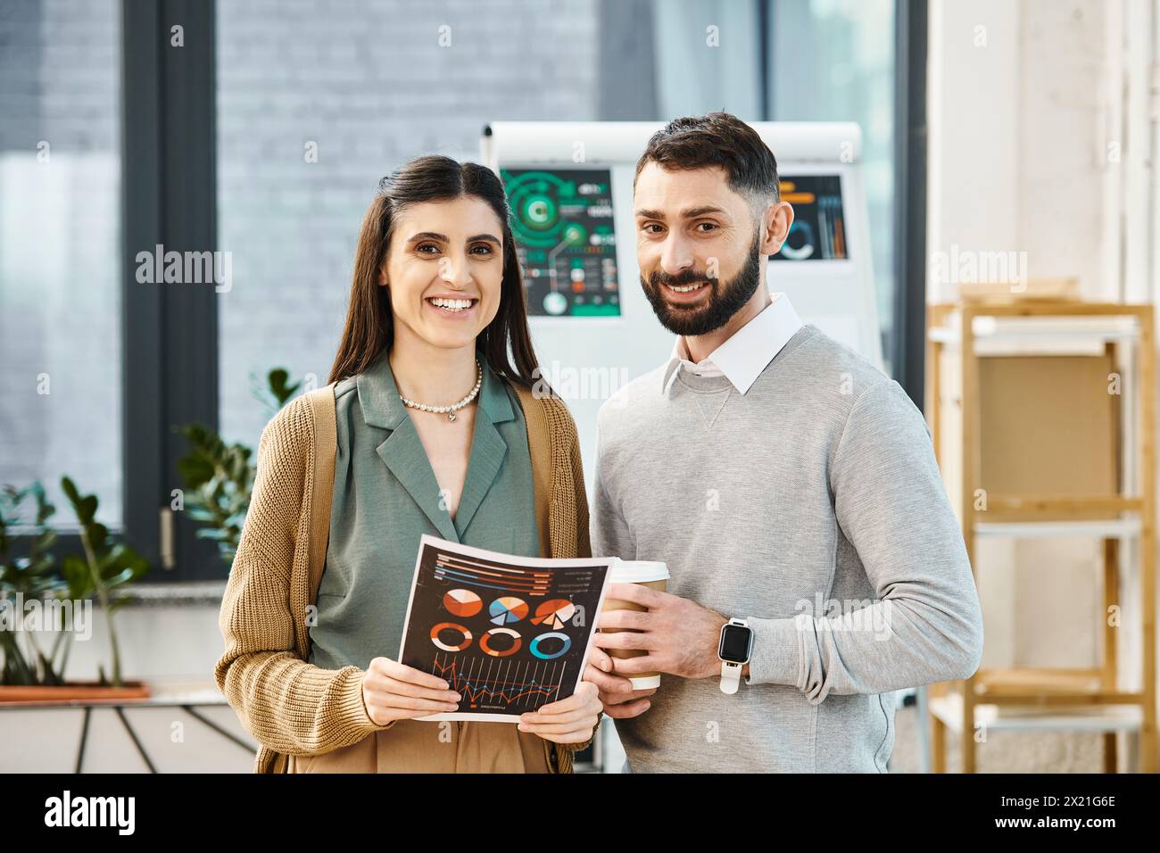 Un homme et une femme dans un cadre d'affaires, debout côte à côte, représentant la collaboration et le travail d'équipe dans un bureau. Banque D'Images