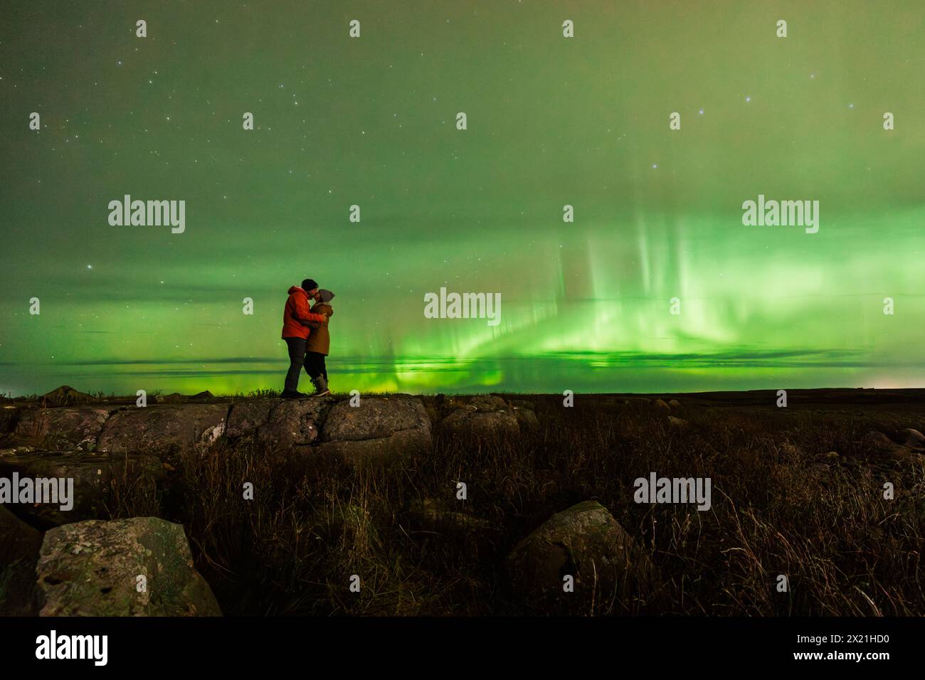 Couple embrassant sous une aurore boréale majestueuse Banque D'Images