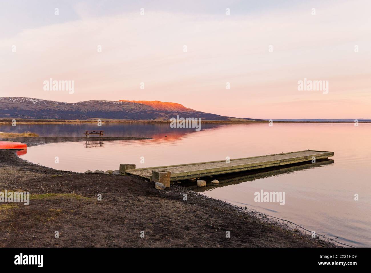 Coucher de soleil aglow, lac tranquille avec une jetée sereine Banque D'Images