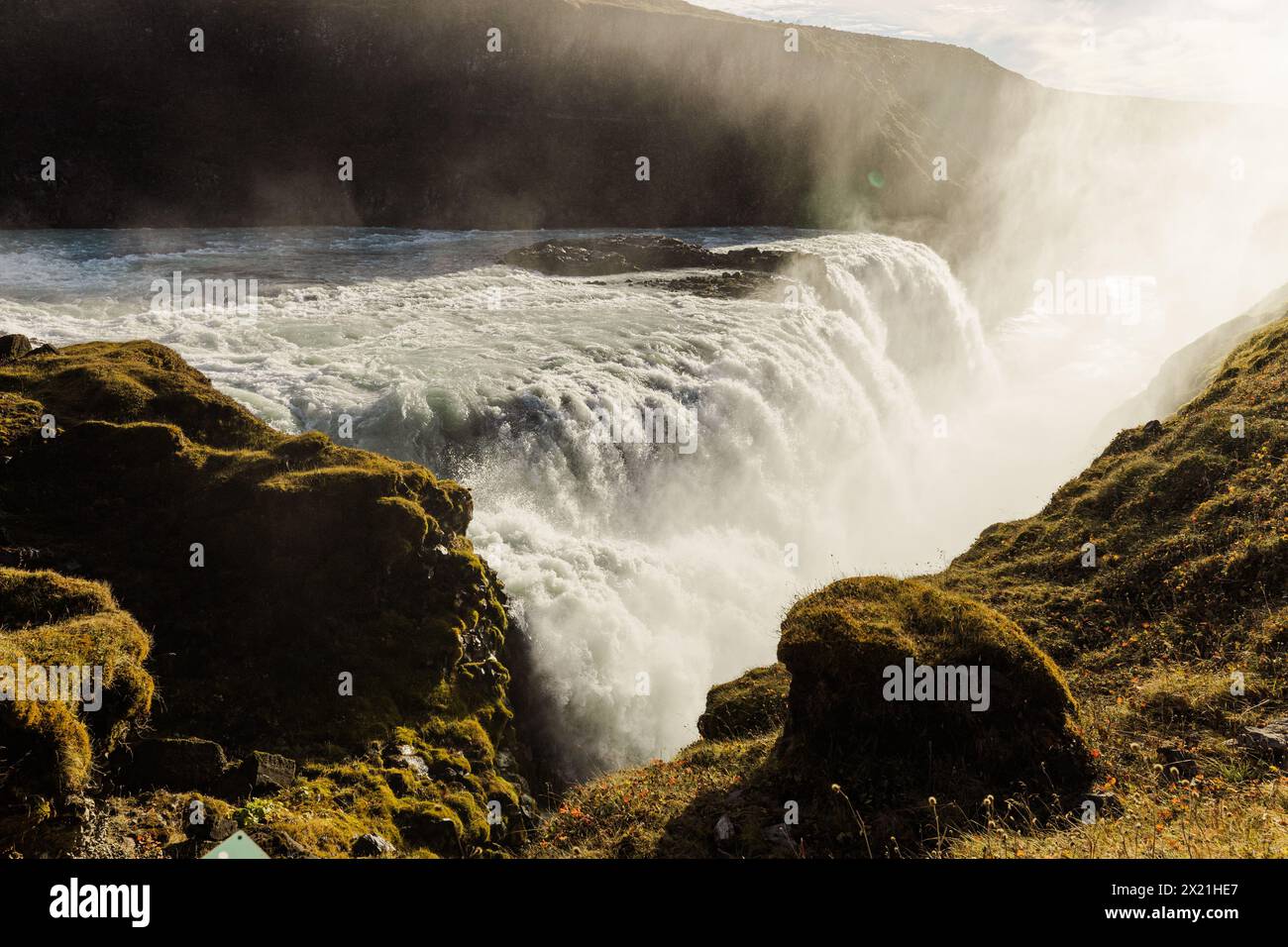 Chute d'eau Gullfoss baignée de soleil en Islande au milieu d'une végétation luxuriante Banque D'Images