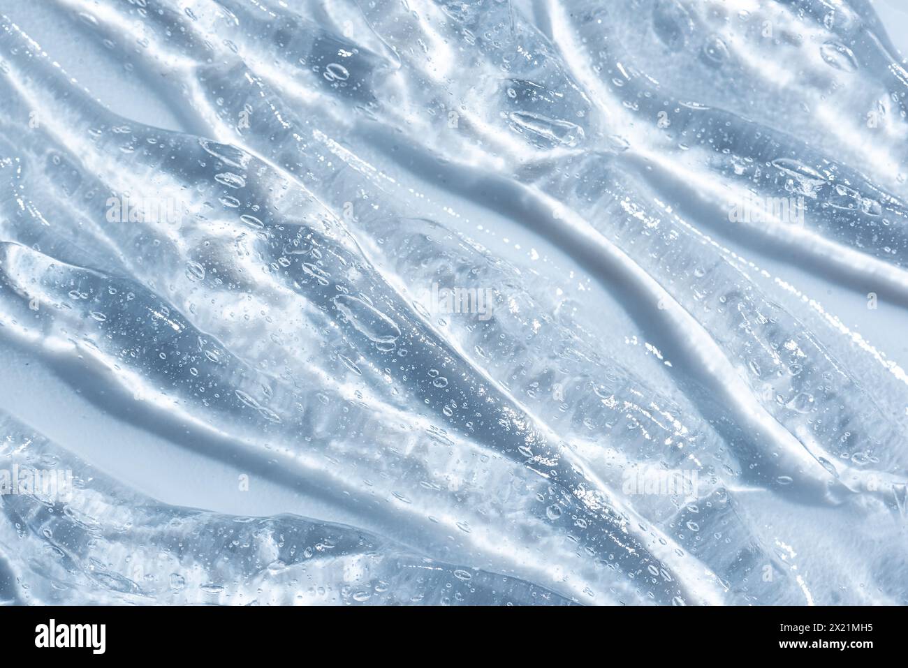 Acide hyaluronique ou gel de collagène pour l'hydratation de la peau. Texture de produit de gel cosmétique en gros plan sur fond bleu. Banque D'Images