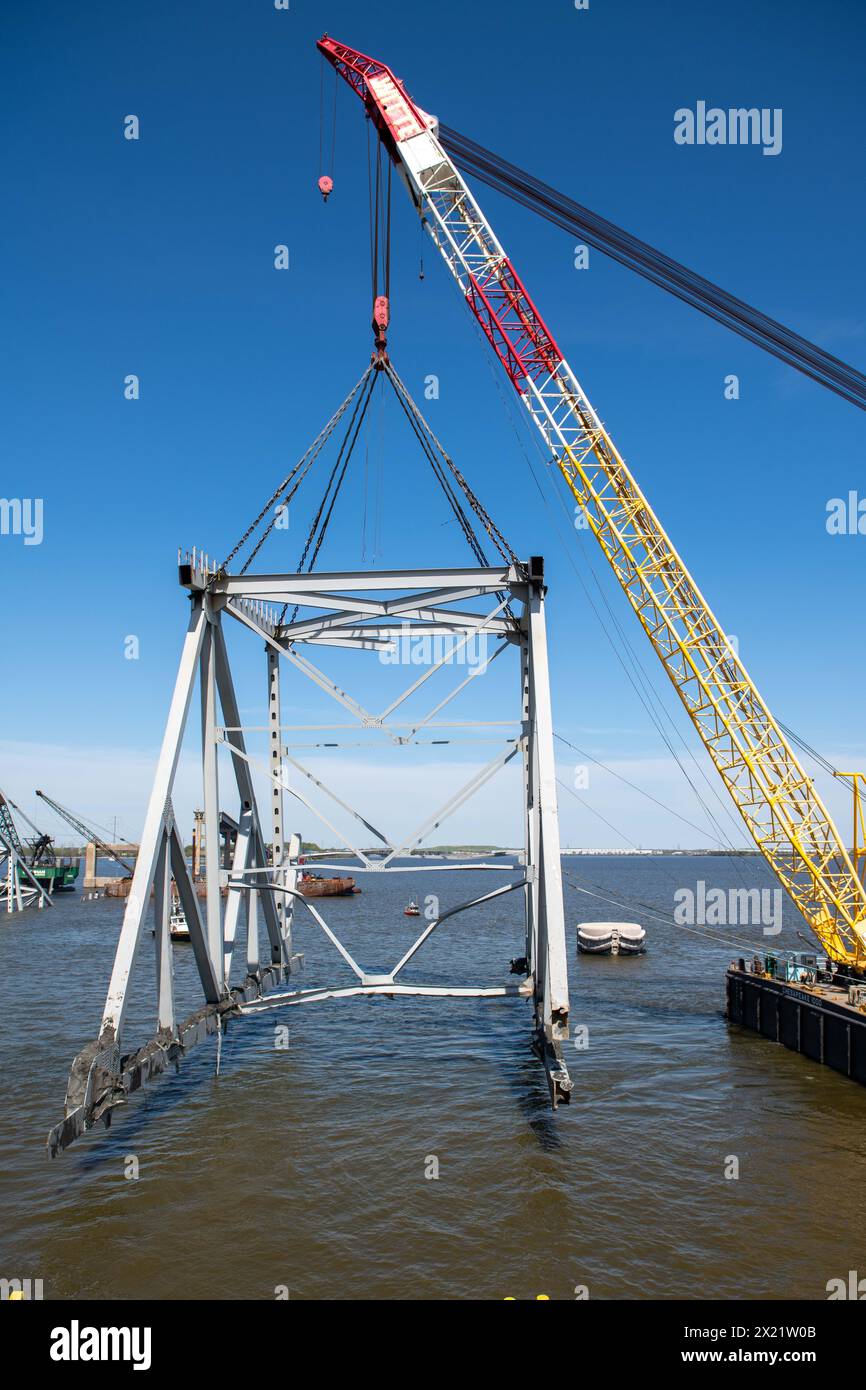 Dundalk (États-Unis d'Amérique). 16 avril 2024. Le Chesapeake, une barge de derrick d'une capacité de levage de 1000 tonnes, soulève une section du pont Francis Scott Key qui bloque le chenal de Fort McHenry, le 16 avril 2024, près de Dundalk, dans le Maryland. Le pont a été heurté par le porte-conteneurs de 984 pieds le 26 mars et s'est effondré tuant six travailleurs. Crédit : MC2 Christine Montgomery/U.S. Navy photo/Alamy Live News Banque D'Images