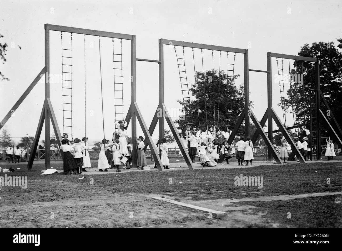 Anneaux et poteaux, Bronx Park, 1911. Montre des enfants jouant sur de l'équipement, y compris probablement des filles des Washington Irving High Schools New York City, qui assistaient à un festival de la journée d'été tenu à Pelham Bay Park dans le Bronx le 23 juin 1911. Banque D'Images