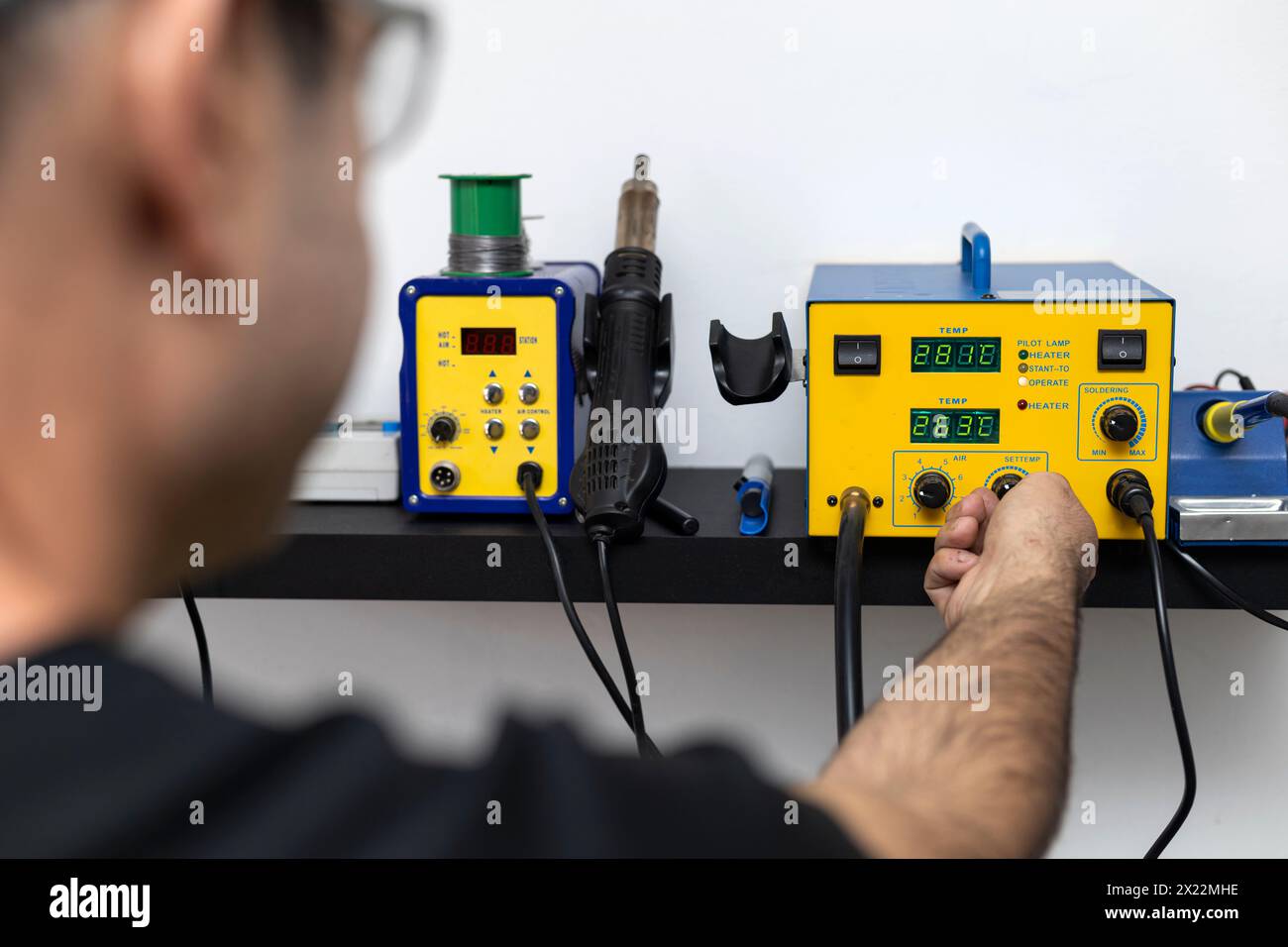 Un technicien en électronique latino-américain teste l'équipement électronique au centre de service. Réparation de concept, électronique Banque D'Images