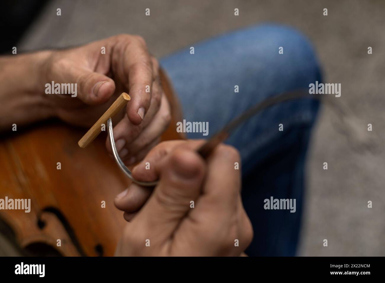 Vue de dessus d'un luthier latino-américain placement dans un outil spécial d'un poteau de son qui est placé à l'intérieur de l'instrument par pression entre le haut et le b. Banque D'Images