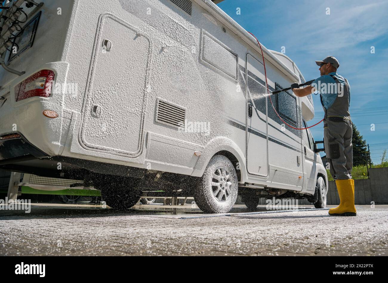 Homme caucasien lavant Motor Home RV en utilisant un détergent mousse puissant Banque D'Images