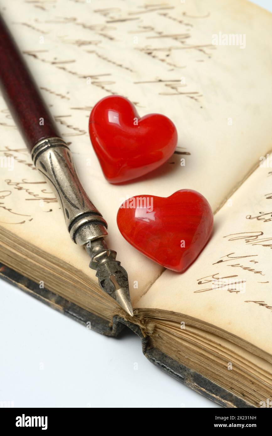 Stylo avec porte-stylo et cœurs rouges sur le journal Banque D'Images