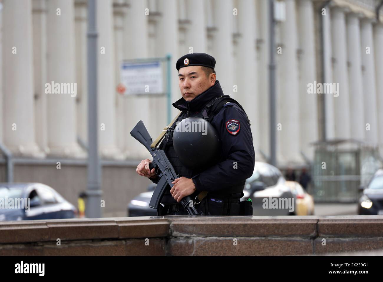 Officier de police russe avec mitrailleuse patrouille dans une rue de la ville au printemps Banque D'Images
