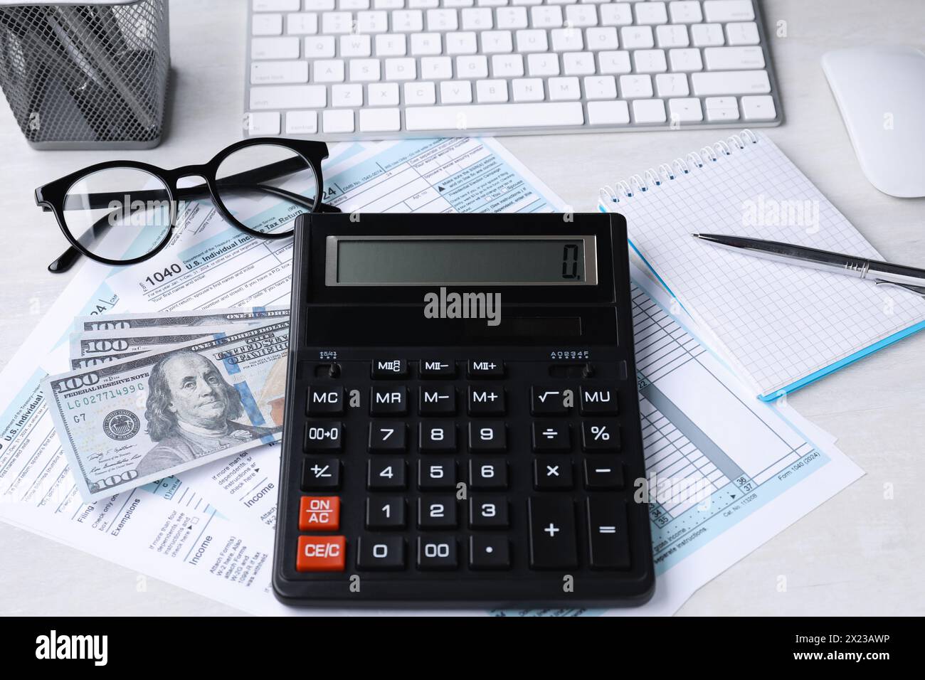 Comptabilité fiscale. Calculatrice, documents, argent, papeterie et lunettes sur table gris clair Banque D'Images