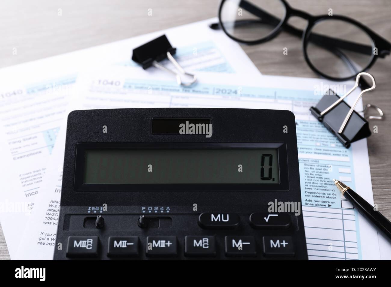 Comptabilité fiscale. Calculatrice, documents, verres et papeterie sur table en bois, gros plan Banque D'Images