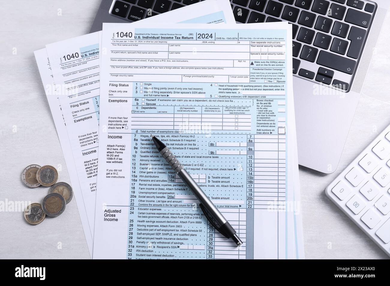 Formulaires fiscaux, pièces de monnaie, stylo, ordinateur portable et calculatrice sur table gris clair, pose à plat Banque D'Images