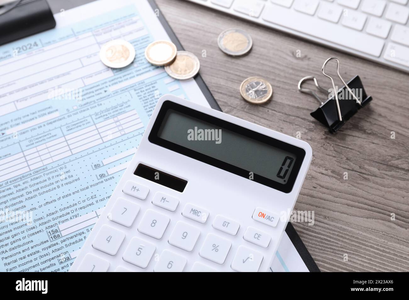 Comptabilité fiscale. Calculatrice, document, pièces de monnaie, clavier et clip de reliure sur la table en bois, gros plan Banque D'Images