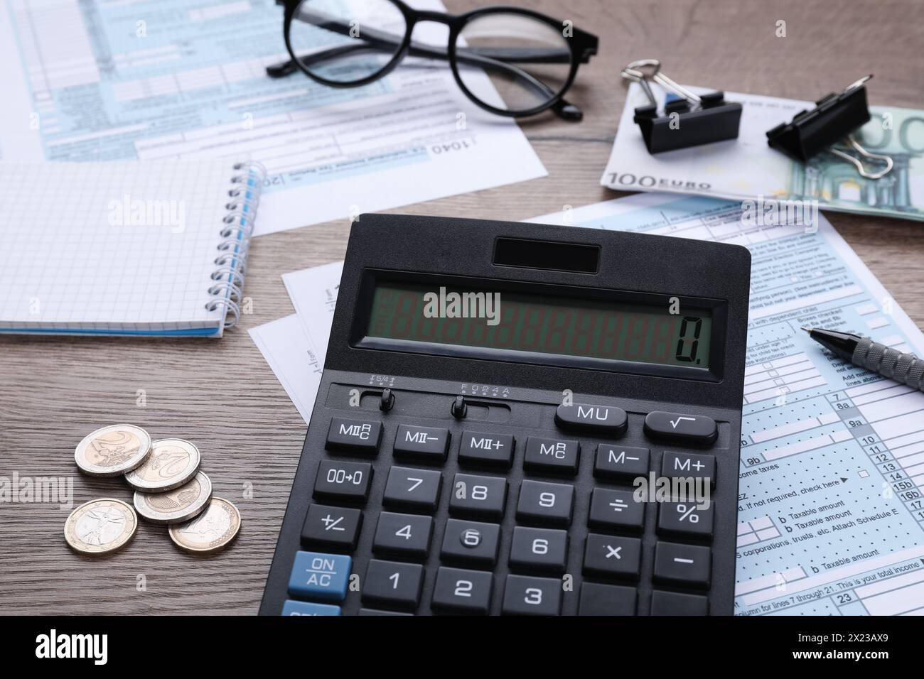 Comptabilité fiscale. Calculatrice, documents, papeterie et verres sur table en bois, gros plan Banque D'Images