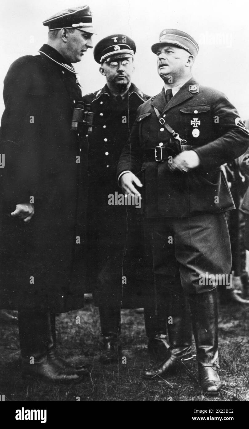 Années 1930 - Allemagne - Ernst Roehm (à droite), chef nazi des troupes de tempête, discute d'une revue de troupes avec le chef de la Gestapo Heinrich Himmler et un subordonné, Gruppenfuhrer Daluege. Banque D'Images