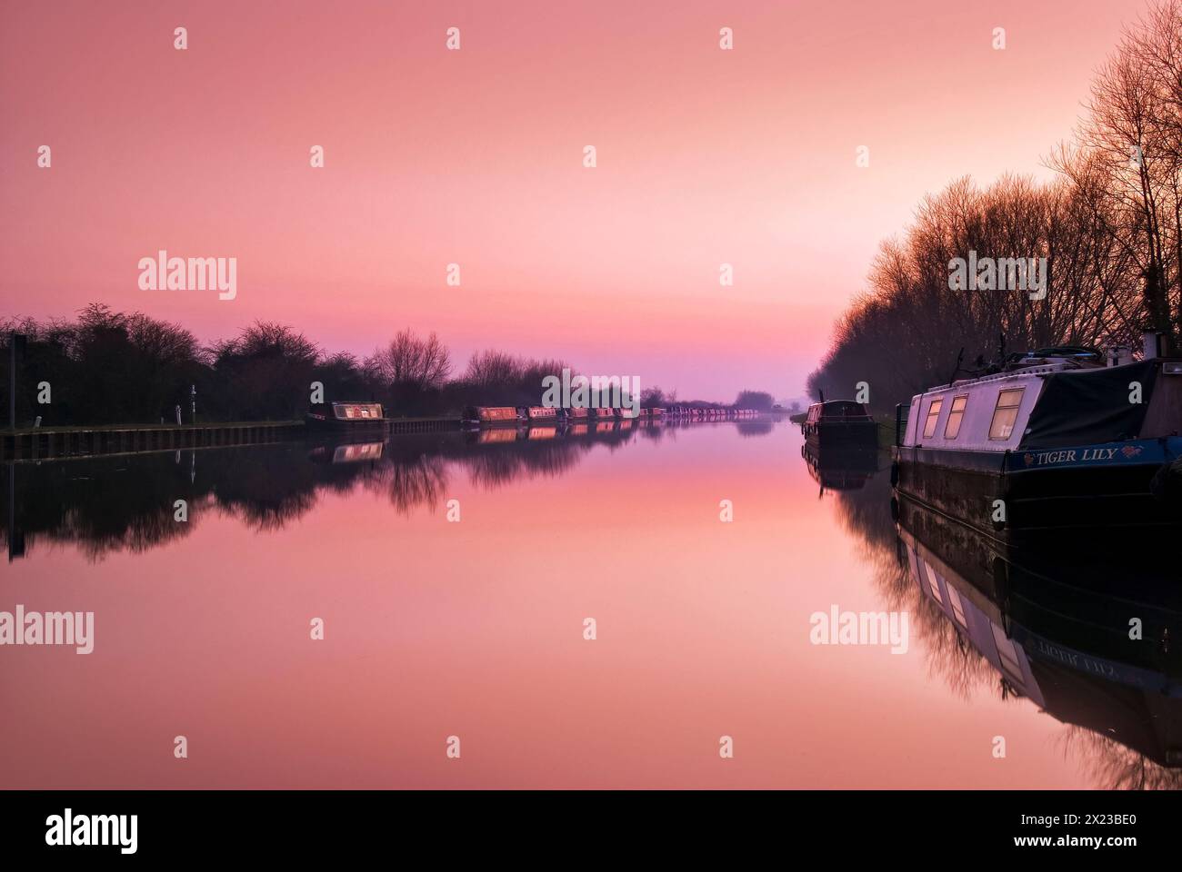 Les hivers coucher de soleil sur le canal de Gloucester et Sharpness à Slimbridge, reflet parfait des bateaux du canal Banque D'Images
