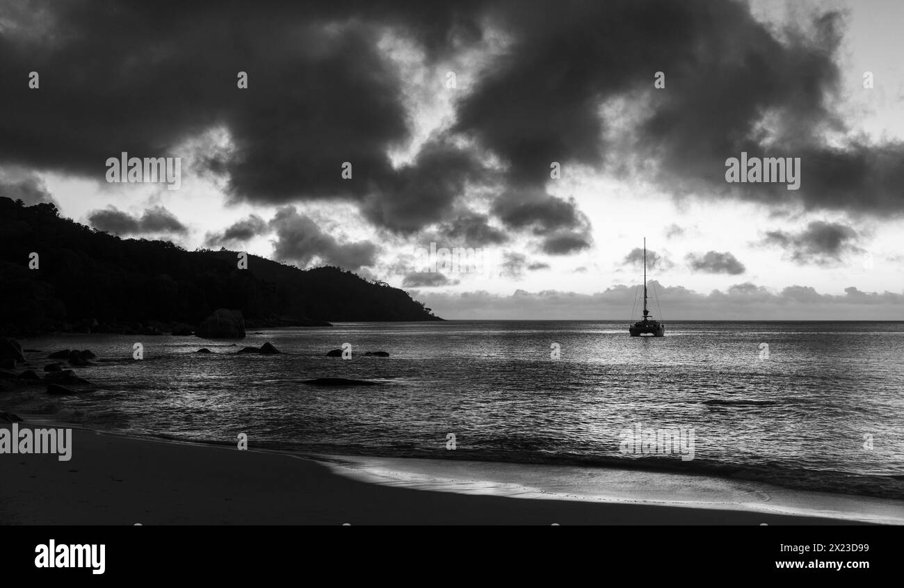 Plage d'anse Lazio sous le ciel coloré du coucher du soleil. Paysage côtier de l'île de Praslin, Seychelles. Photo noir et blanc Banque D'Images