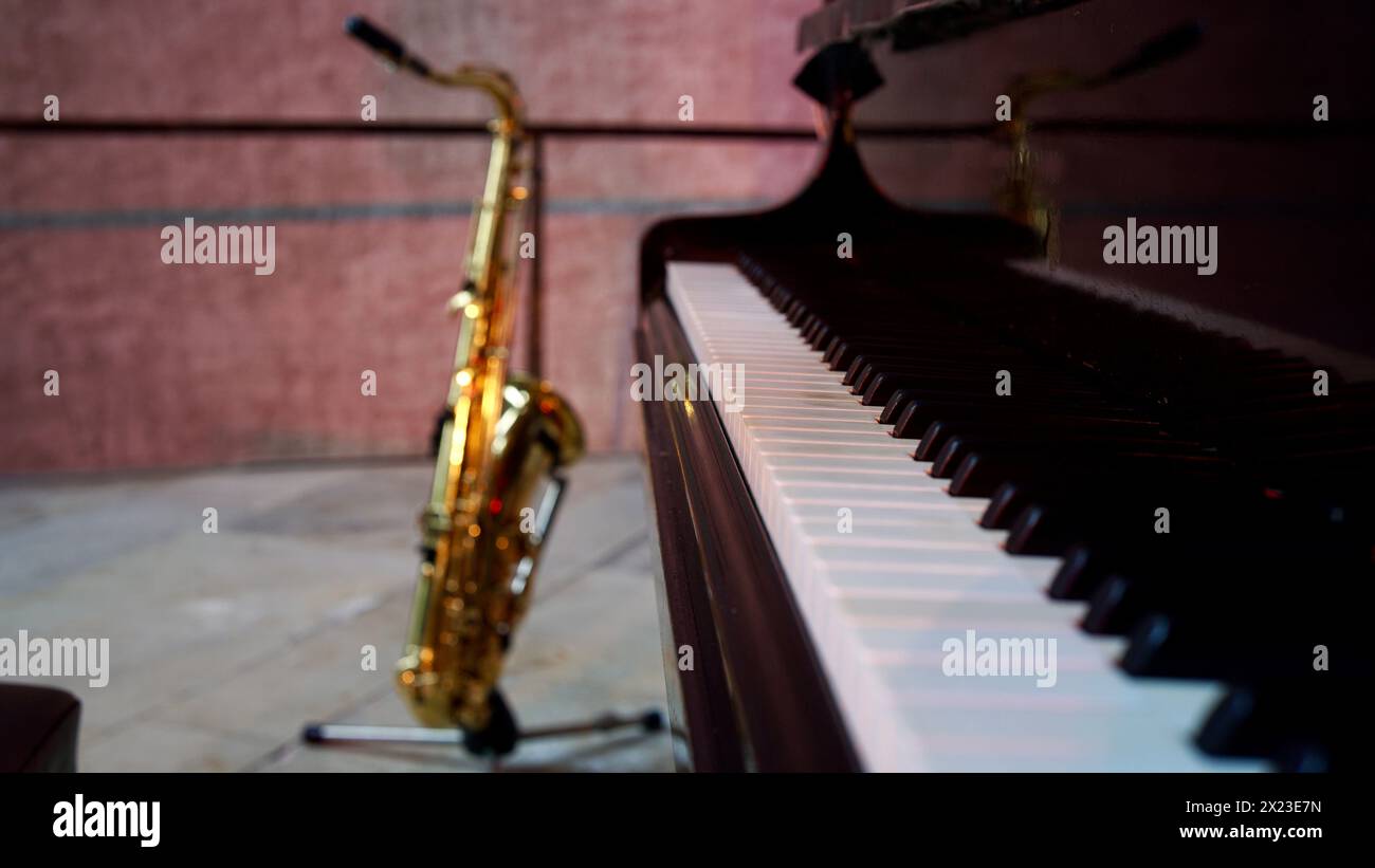 Un piano à queue et un saxophone ténor sur scène. Banque D'Images