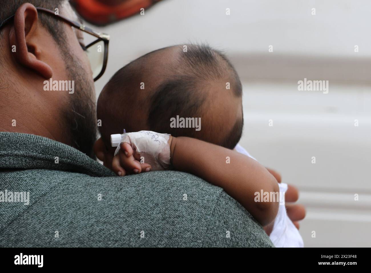 Dhaka, Bangladesh . 18 avril 2024. Un homme portant son bébé est vu après avoir évacué l'hôpital pour enfants du Bangladesh, après un incendie causé par un climatiseur dans l'unité de soins intensifs cardiaques. Le 18 avril 2024, Dhaka, Bangladesh. (Photo de S A Masum/Eyepix Group/Sipa USA) crédit : Sipa USA/Alamy Live News Banque D'Images