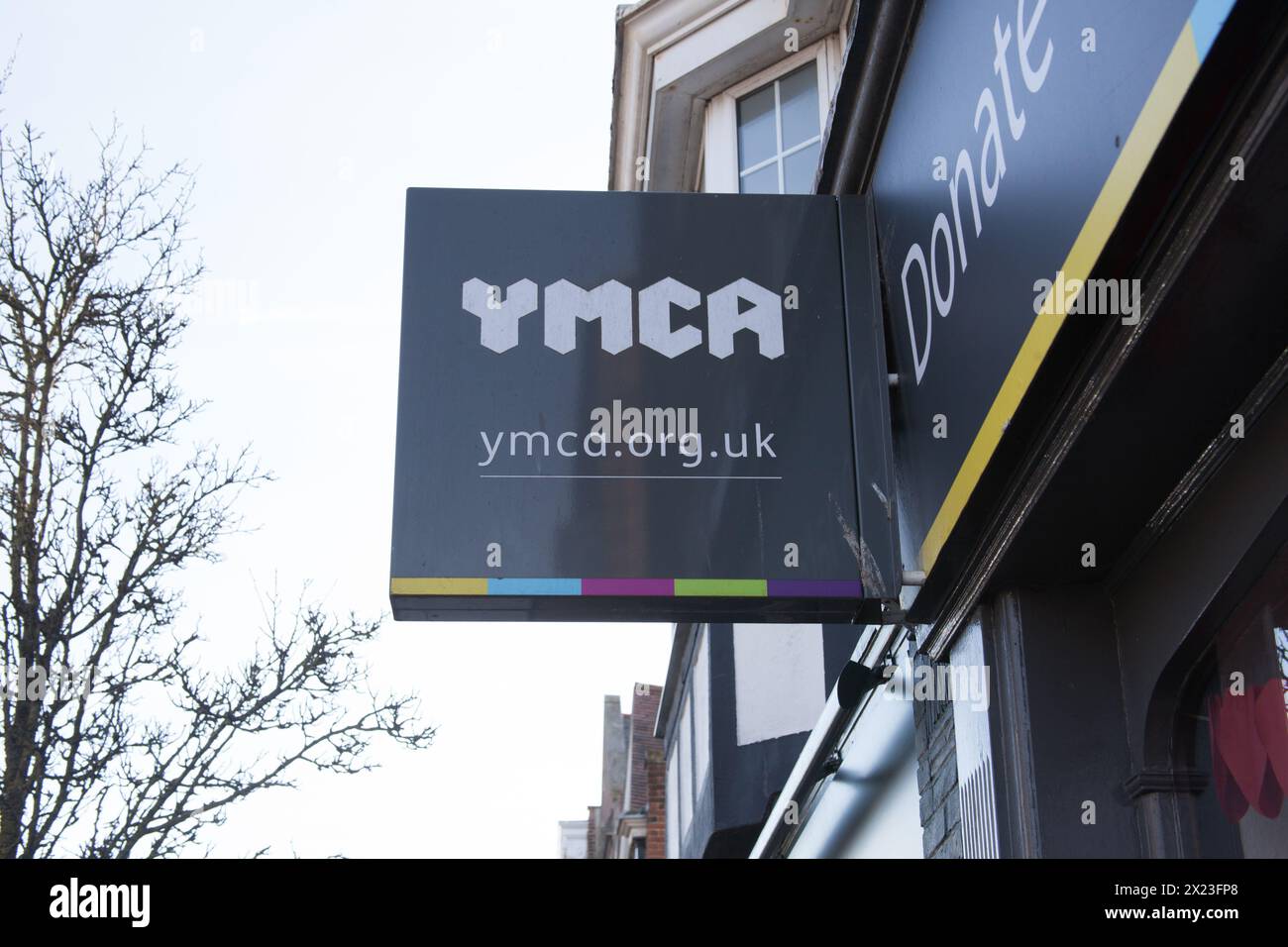 Une enseigne du YMCA devant un magasin de charité à Frinton, Essex au Royaume-Uni Banque D'Images