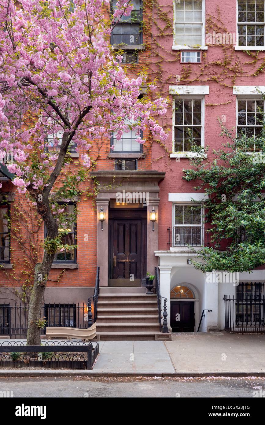 Maison de ville dans le quartier historique de Greenwich Village avec des arbres en fleurs au printemps. West Village, Manhattan, New York Banque D'Images