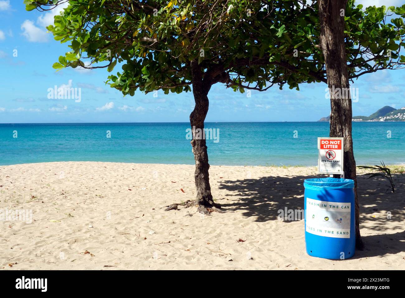 Poubelle avec panneau d'avertissement, ne jetez pas de déchets, sur une plage de sable romantique avec mer bleu Azur à Castries, Sainte-Lucie. Banque D'Images