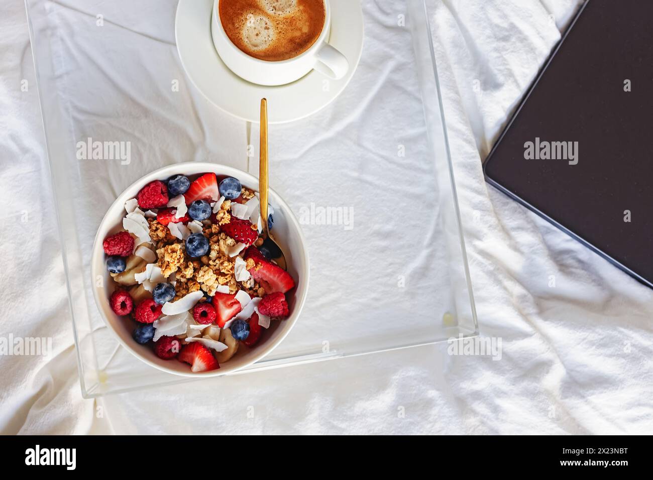 Petit déjeuner avec bol de granola yaourt surmonté de baies et de café, vue du haut Banque D'Images