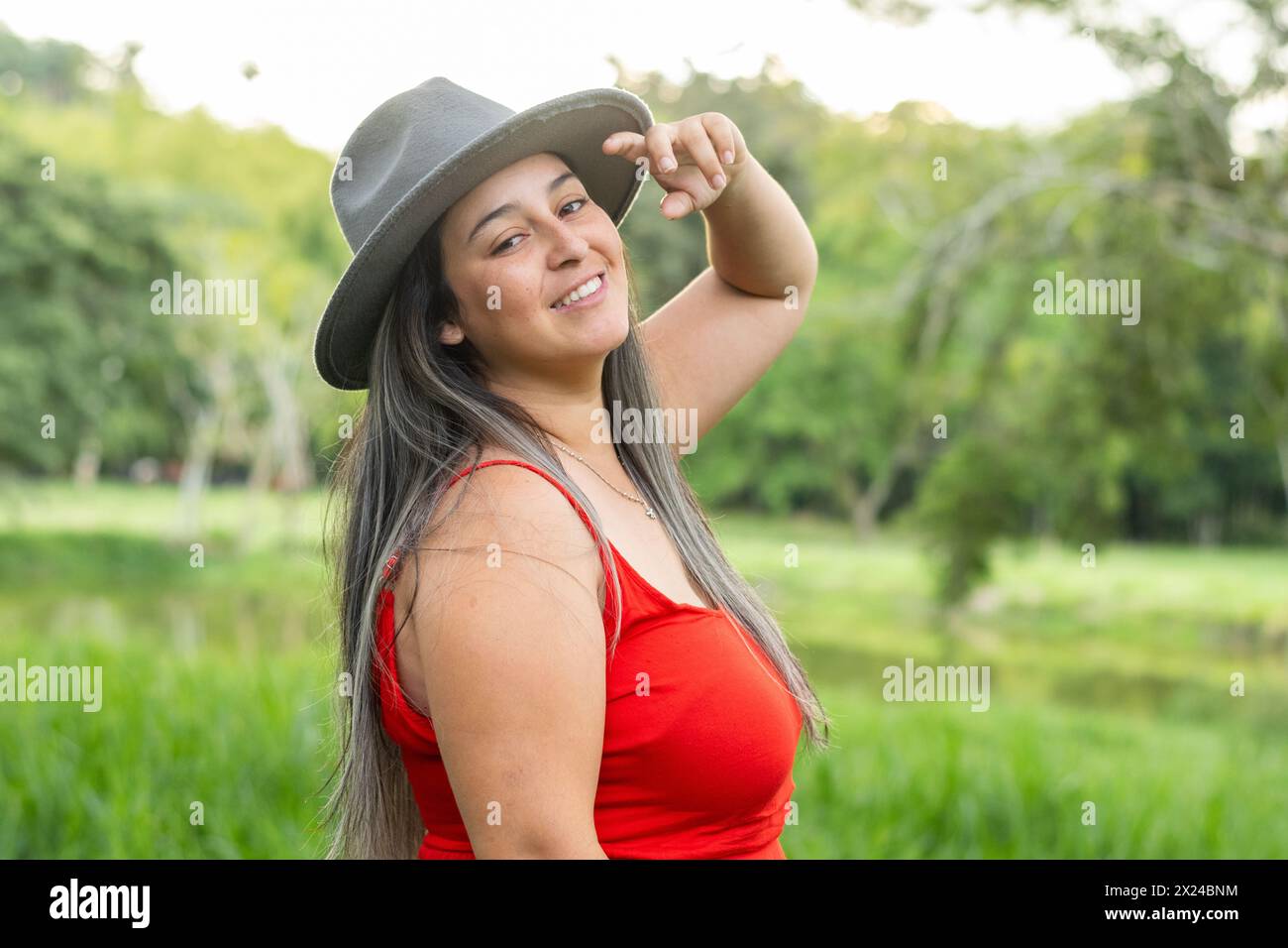 très heureuse femme latina marchant dans la campagne tout en souriant et en regardant d'un côté Banque D'Images