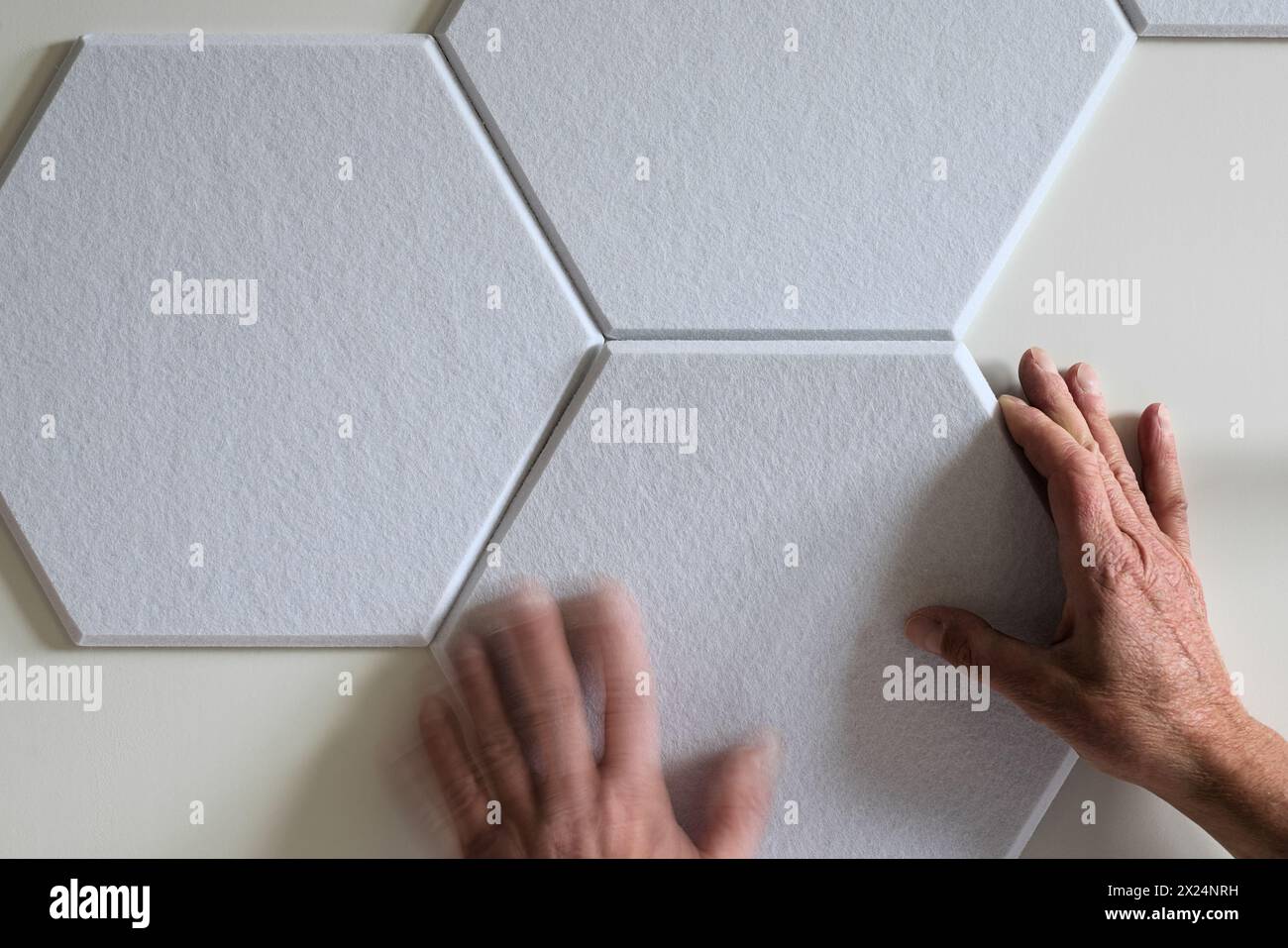 Installer des dalles de panneau acoustique de plafond mural hexagonal pour l'insonorisation et la réduction de l'isolation par absorption des modes soniques de la pièce Banque D'Images