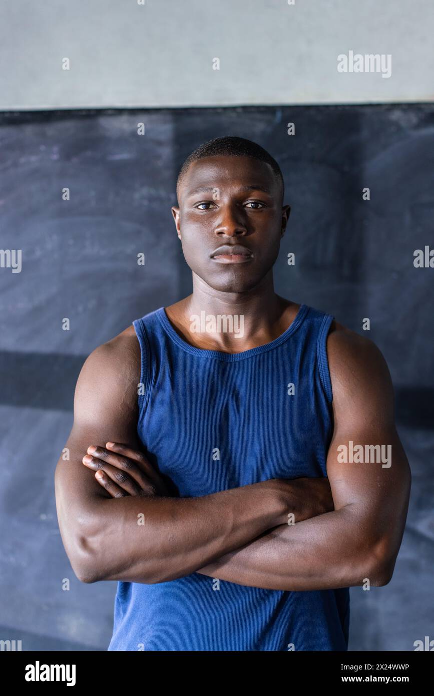 Athlète masculin noir confiant, bras croisés dans la salle de gym, espace de copie Banque D'Images