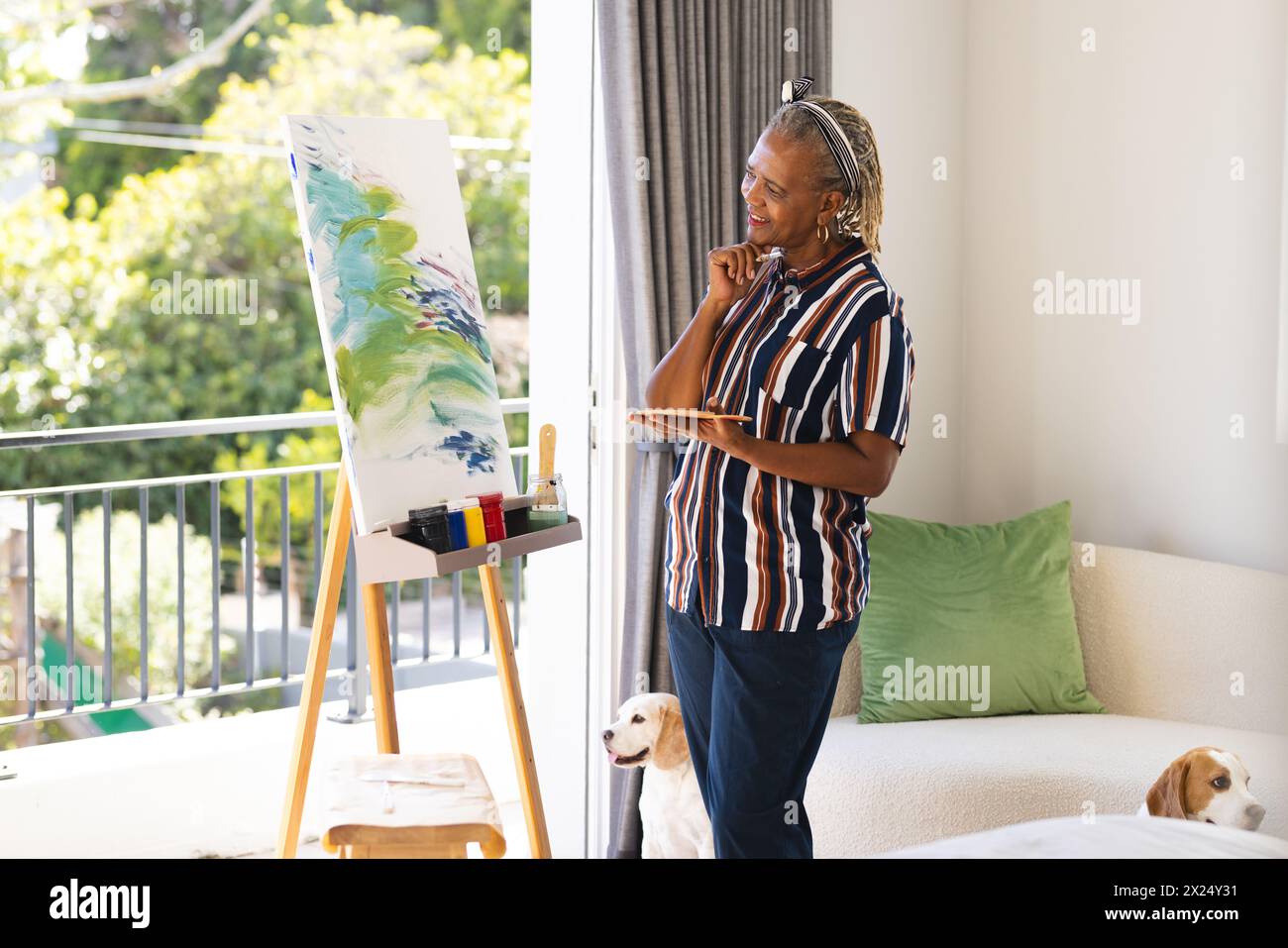 Une femme afro-américaine senior aux cheveux gris peint sur toile à la maison Banque D'Images