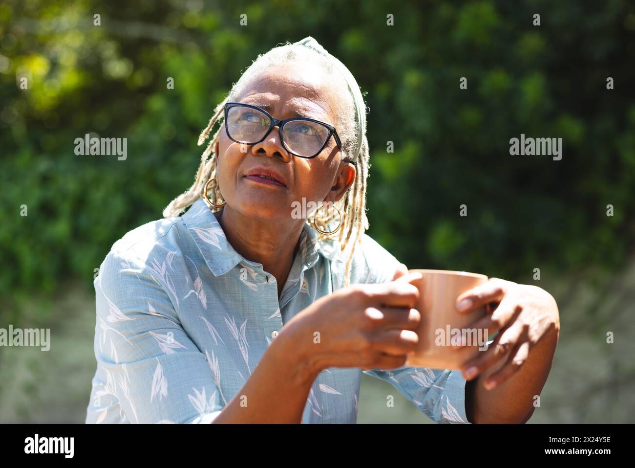 Une femme afro-américaine senior avec des lunettes regarde à la maison, copie l'espace Banque D'Images