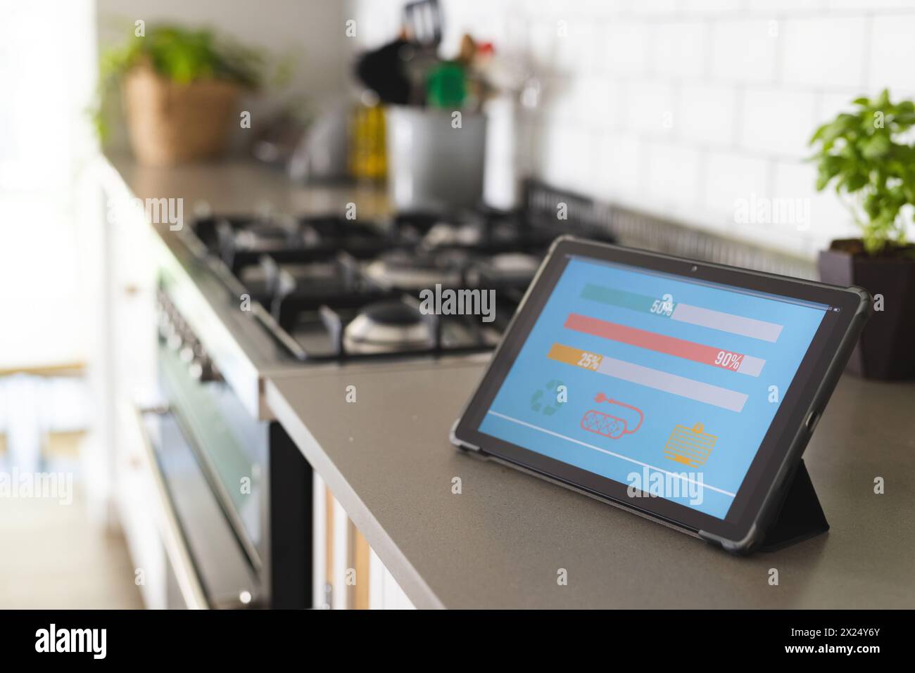 Une tablette affichant des graphiques colorés de la consommation d'énergie de l'application maison intelligente se trouve sur le comptoir de la cuisine Banque D'Images