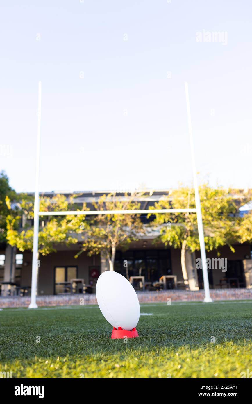 Un ballon de rugby est prêt pour le coup d'envoi sur un terrain lumineux à l'extérieur, espace de copie Banque D'Images