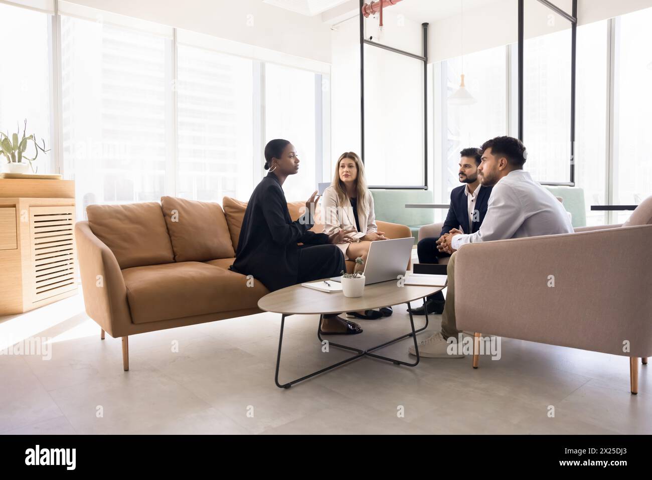 Jeune femme professionnelle afro-américaine parlant à une équipe diversifiée Banque D'Images