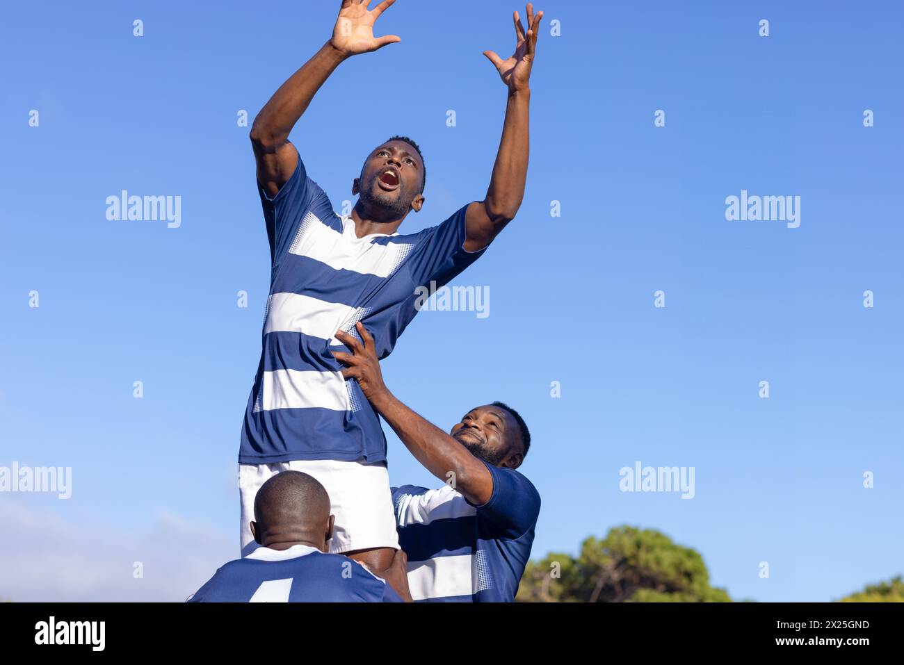 Trois jeunes athlètes afro-américains s'entraînant sur le terrain, jouant au rugby, espace copie Banque D'Images