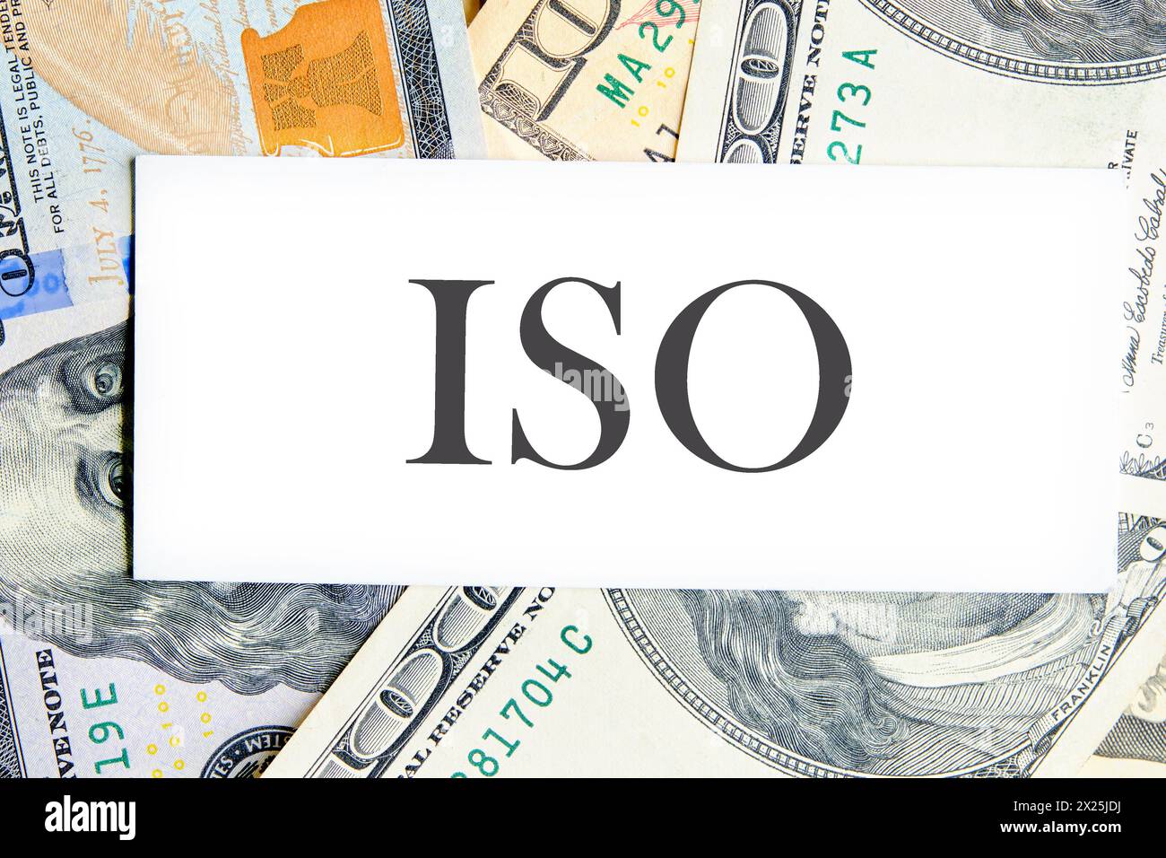 ISO. Organisation internationale de normalisation. Un mot ISO sur une carte de visite blanche couchée sur des dollars Banque D'Images