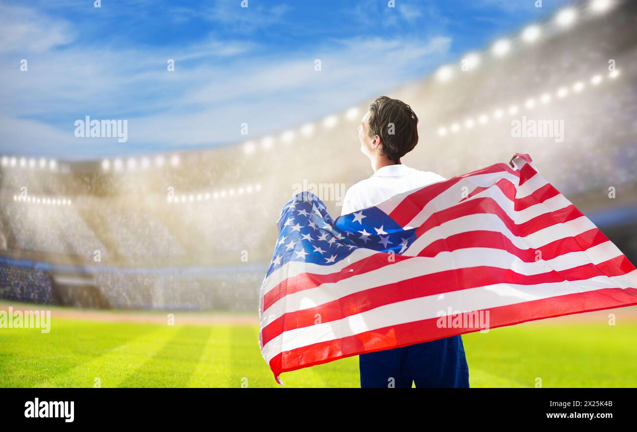 Supporter américain de football sur le stade. LES fans AMÉRICAINS sur le terrain de football regardent l'équipe jouer. Groupe de supporters américains avec drapeau et maillot national Banque D'Images