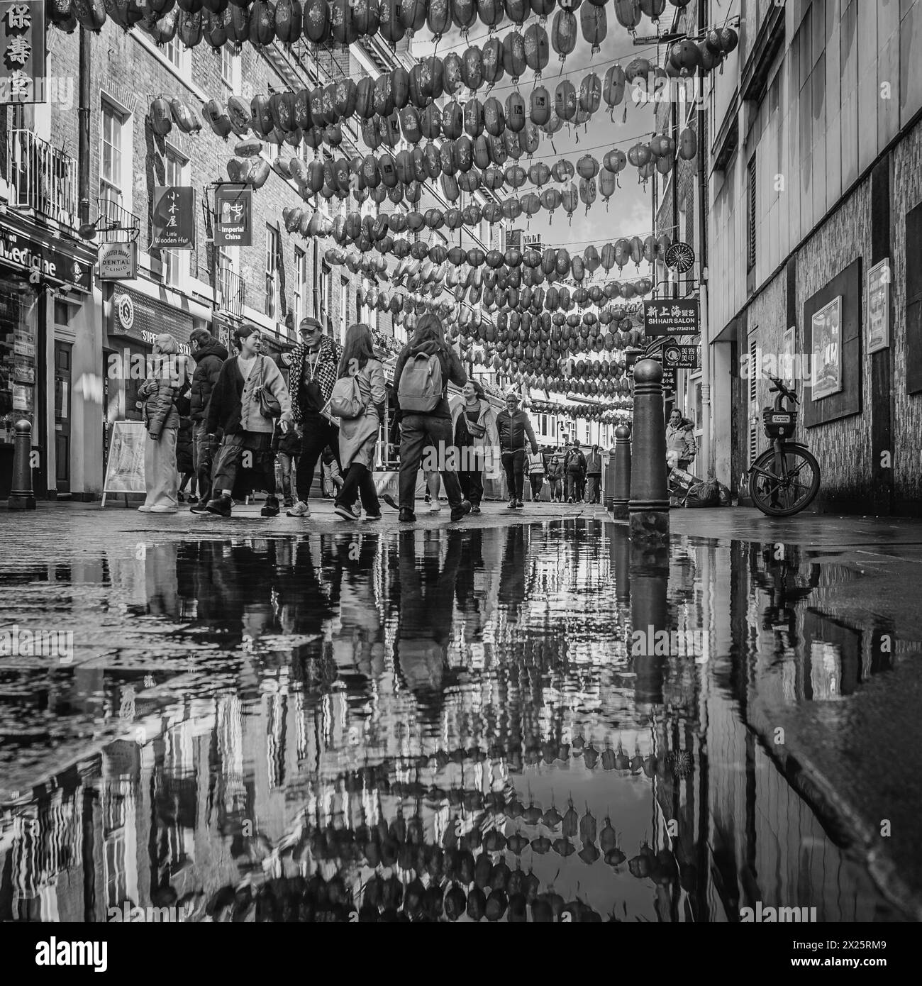 Image en noir et blanc de touristes marchant dans une rue de chinatown, Londres. Banque D'Images