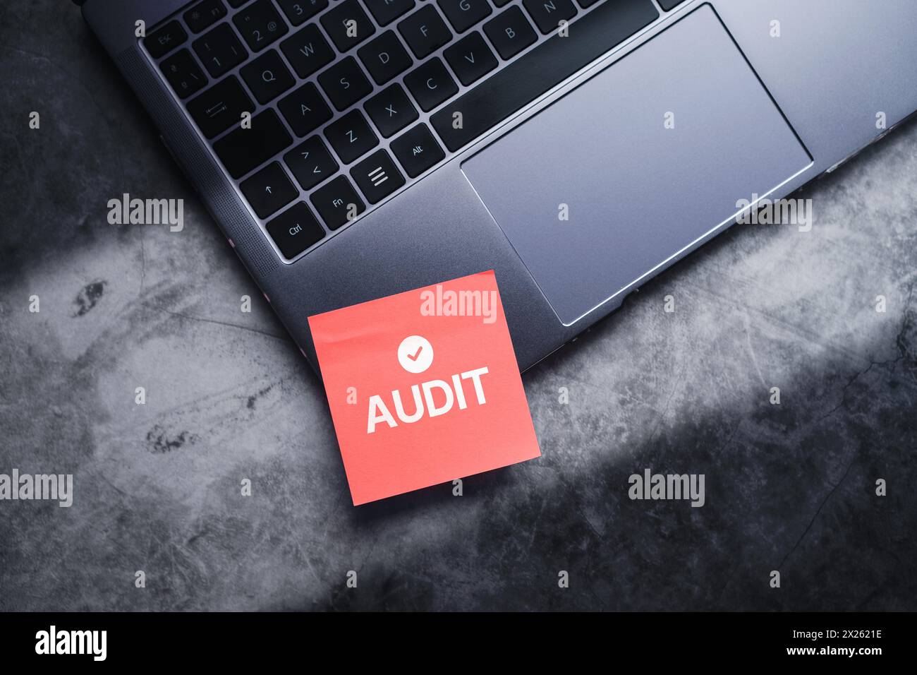 Photo en vue supérieure d'une note adhésive rouge collée sur un ordinateur portable. Concept d'audit commercial. Examen et évaluation du compte financier. Compte de résultat. Banque D'Images