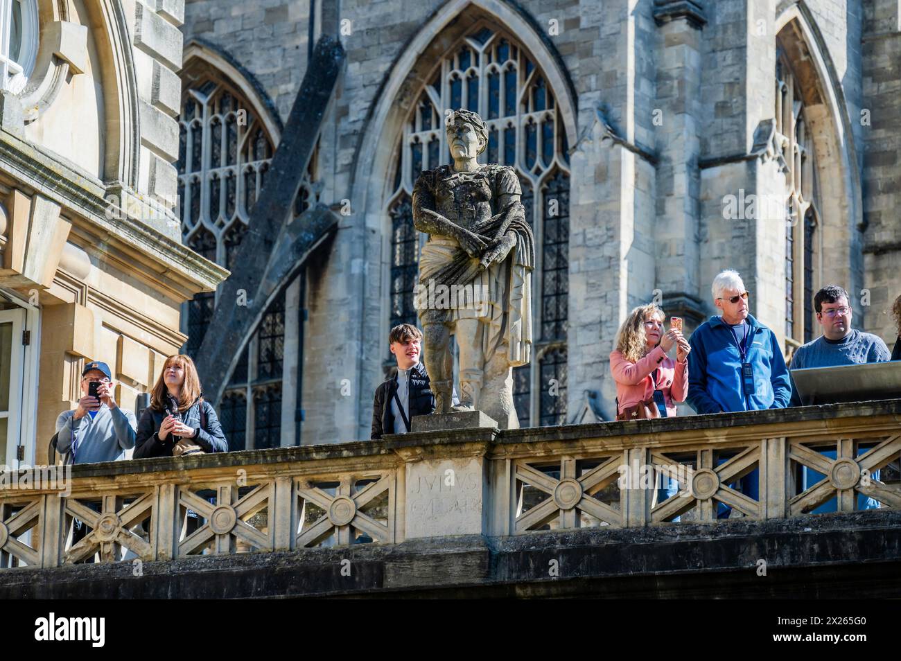Bath, Royaume-Uni. 20 avril 2024. Les visiteurs (et une statue de Jules César) des thermes romains apprécient le temps estival alors qu'il retourne brièvement à Bath. Crédit : Guy Bell/Alamy Live News Banque D'Images