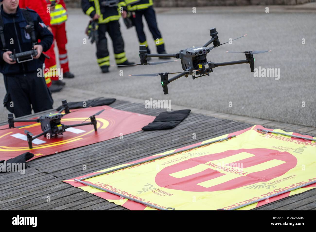 Schweinfurt, Allemagne. 20 avril 2024. Un drone décolle de la rive principale à Schweinfurt tandis que les pompiers se tiennent autour de lui. Les pompiers de la ville et du district de Schweinfurt et les unités de secours en eau pratiquent une situation de catastrophe sur le main. Un déversement de pétrole sur l'eau courante est présumé. Les drones sont également de plus en plus utilisés pour faire une première évaluation de la situation. Crédit : Pia Bayer/dpa/Alamy Live News Banque D'Images