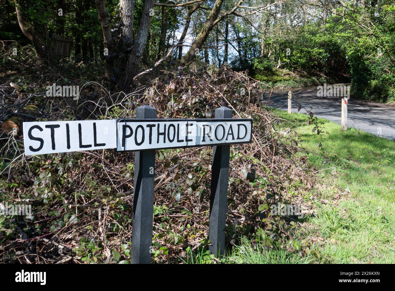 Panneau routier avec le nom de rue réel remplacé par les mots Still Pothole Road probablement par un conducteur local frustré par les nids de poule non réparés, Royaume-Uni Banque D'Images