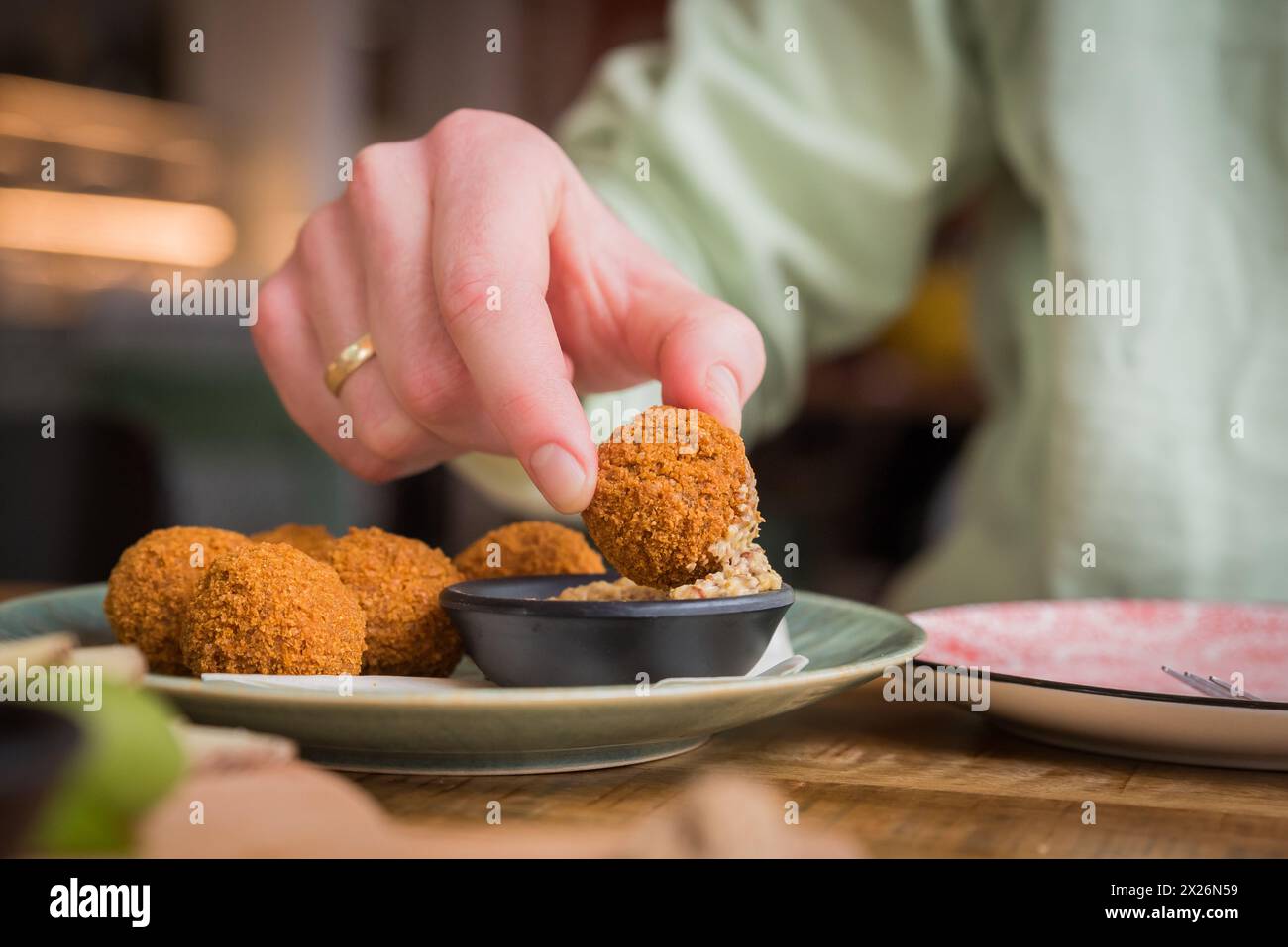 Gros plan sur le bitterballen hollandais traditionnel trempé dans de la moutarde dans un café-restaurant aux pays-Bas Banque D'Images