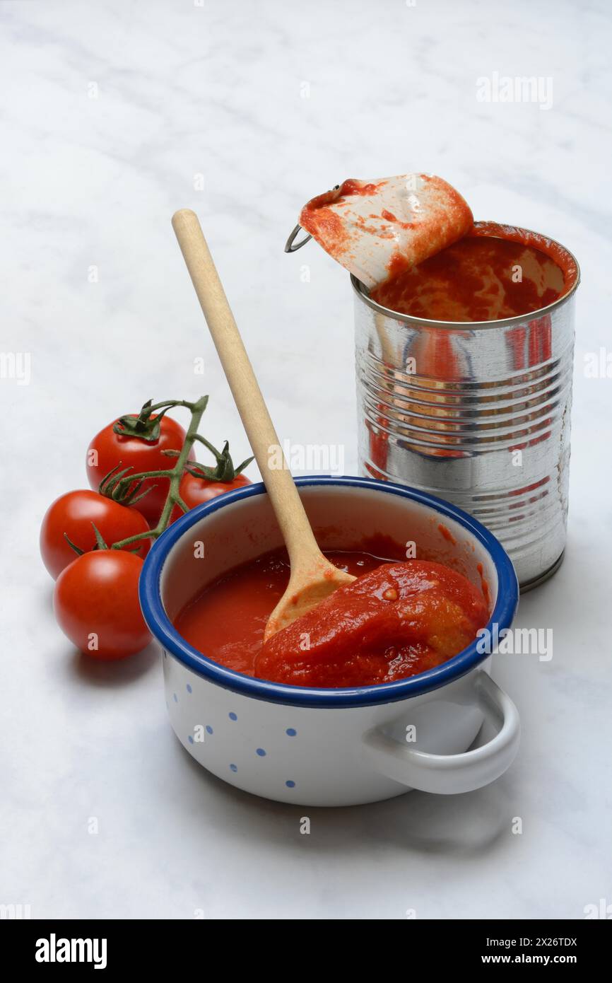 Tomates en conserve dans un bol, boîte de conserve et tomates Banque D'Images