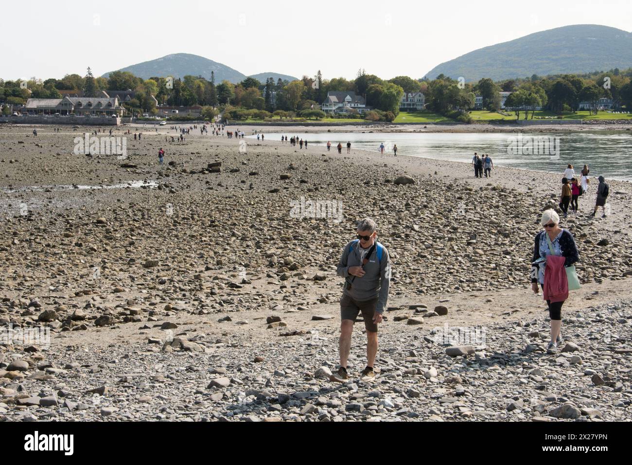 Les touristes marchant sur le banc de sable exposé reliant Bar Harbor et Bar Island à marée basse dans la baie de Frenchman. En regardant Bar Harbor. Mount dessert Island, mai Banque D'Images