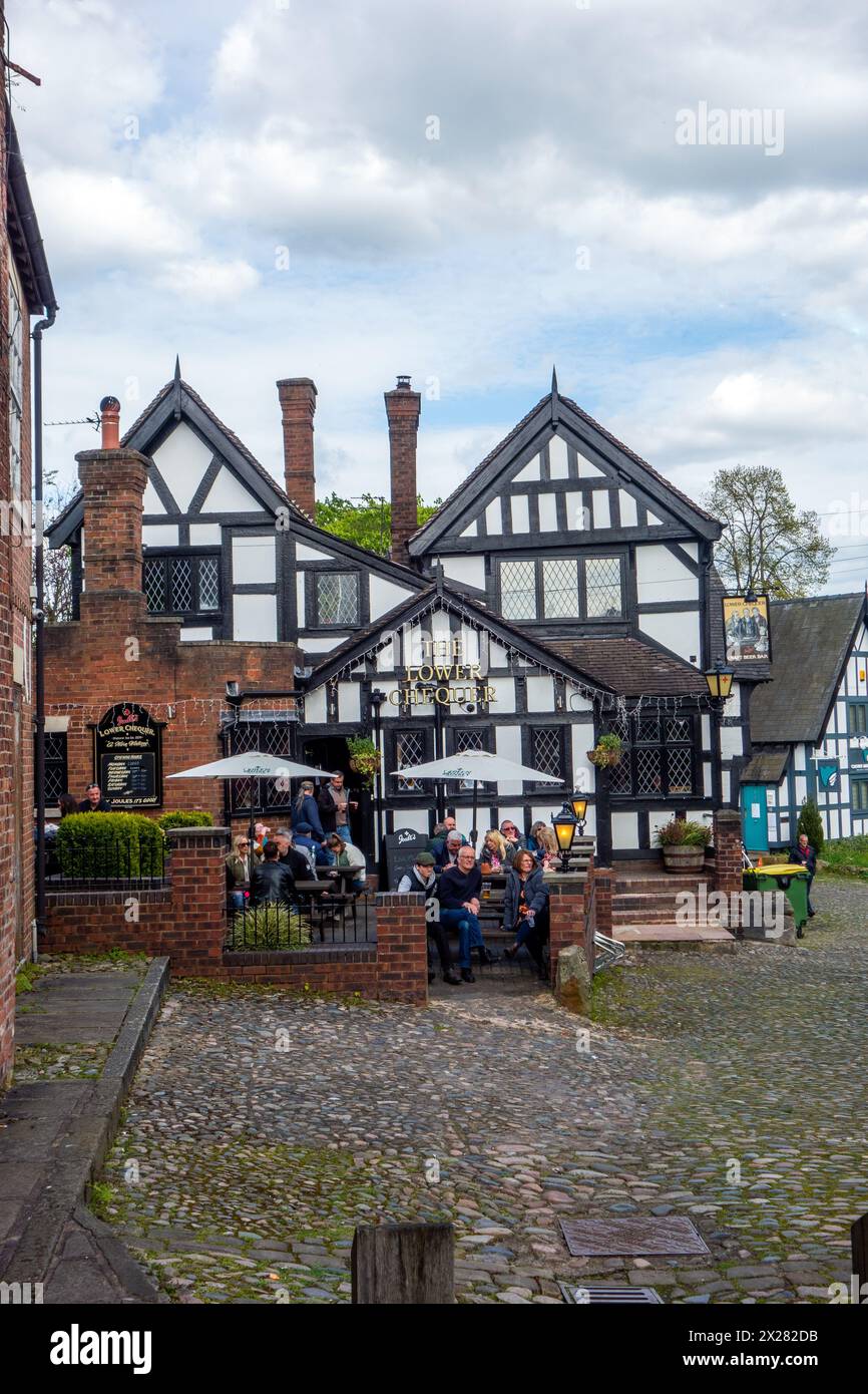 Les gens de boire et de profiter du soleil à l'extérieur de la partie inférieure, un damier noir et blanc Tudor inn dans la ville de marché de l'Angleterre Cheshire Sandbach Banque D'Images