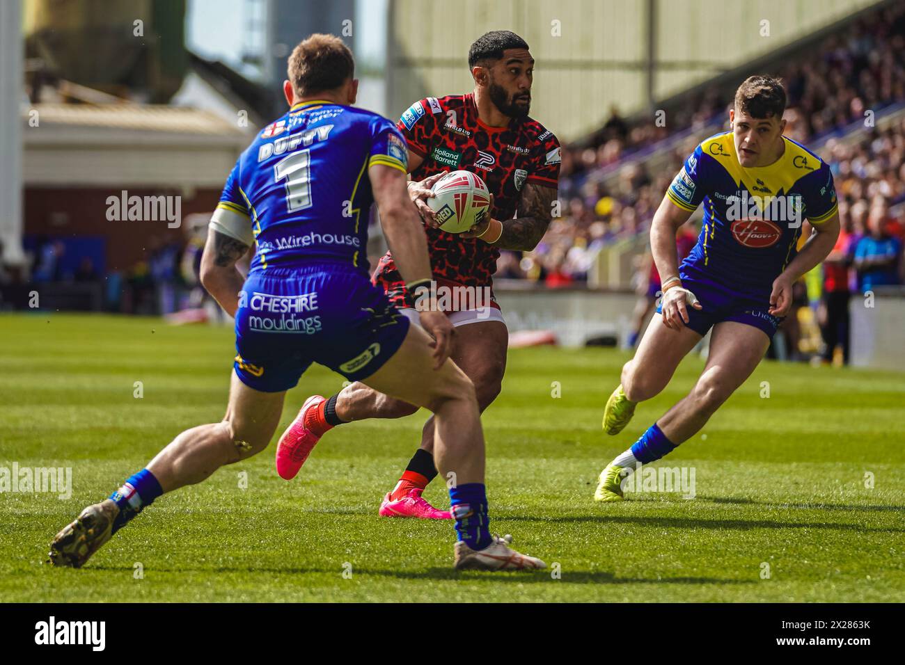 Warrington, Cheshire, Royaume-Uni. 20 avril 2024. Super League Rugby : Warrington Wolves vs Leigh Leopards au stade Halliwell Jones. JOHN ASIATA à la recherche du déchargement comme MATT DUFTY cherche à faire le tacle. Crédit James Giblin/Alamy Live News. Banque D'Images