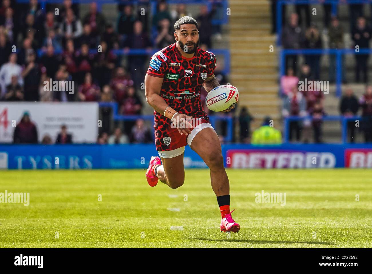 Warrington, Cheshire, Royaume-Uni. 20 avril 2024. Super League Rugby : Warrington Wolves vs Leigh Leopards au stade Halliwell Jones. JOHN ASIATA portant le ballon dans une main alors qu'il attaque la ligne Warrington. Crédit James Giblin/Alamy Live News. Banque D'Images