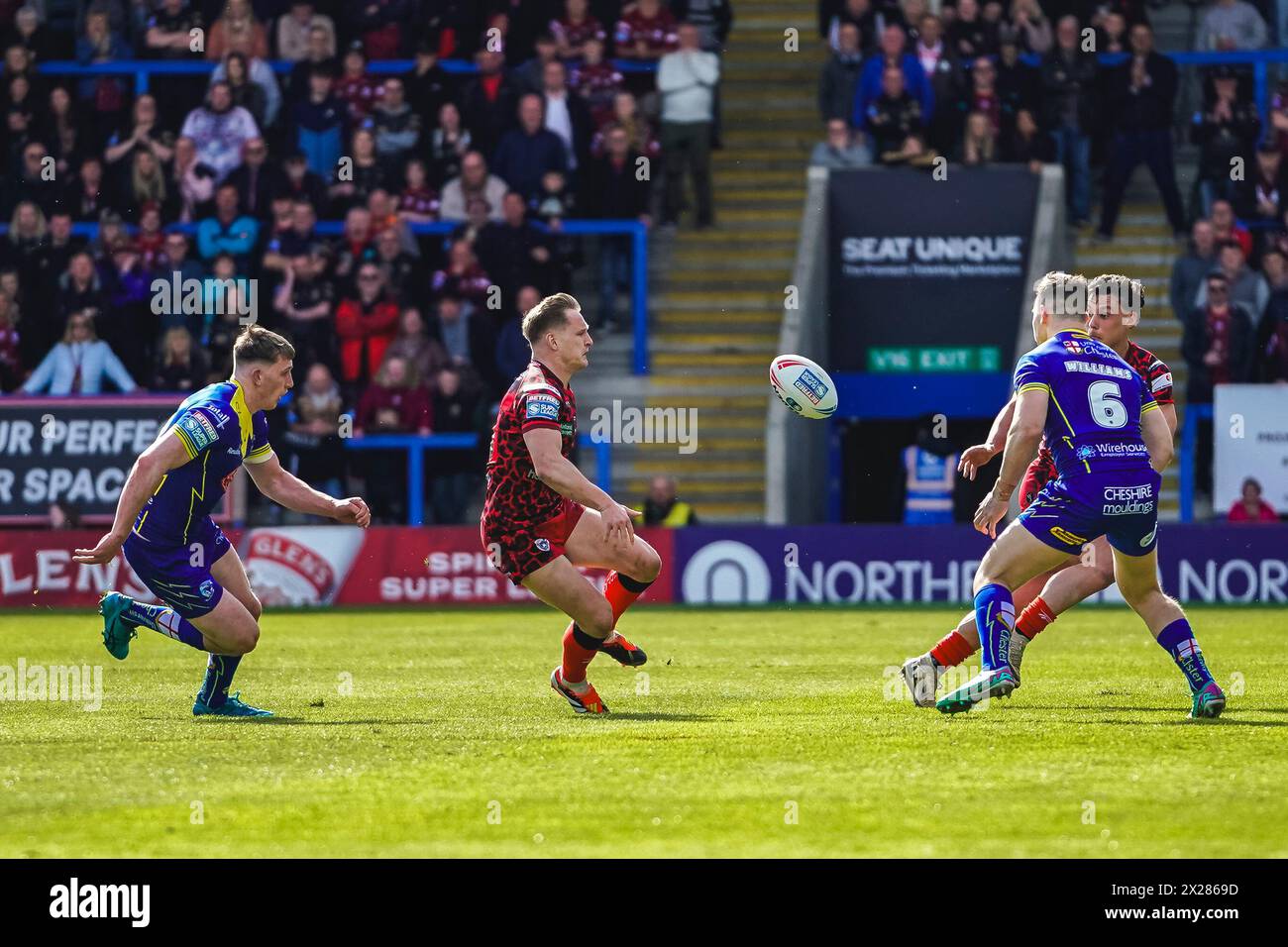 Warrington, Cheshire, Royaume-Uni. 20 avril 2024. Super League Rugby : Warrington Wolves vs Leigh Leopards au stade Halliwell Jones. BRAD DWYER fait la passe alors que MATTY ASHTON cherche à faire le tacle, crédit James Giblin/Alamy Live News. Banque D'Images
